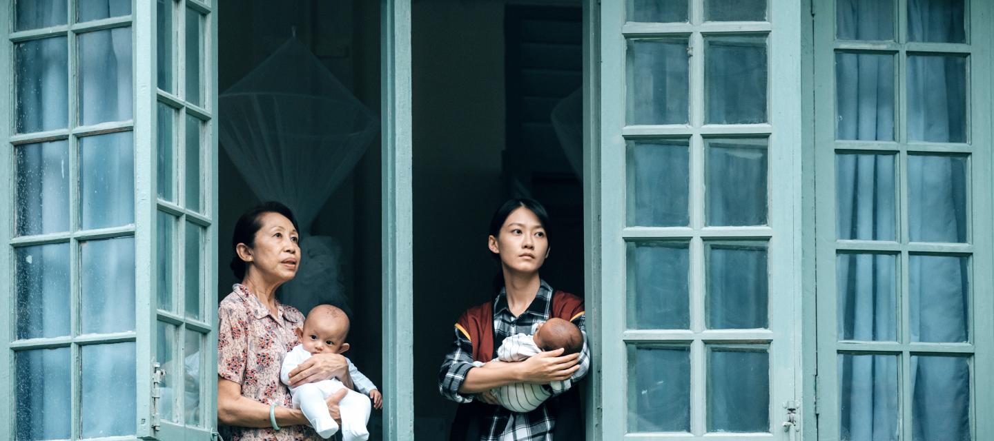 Deux femmes à la fenêtre chacune avec un nourrisson dans les bras