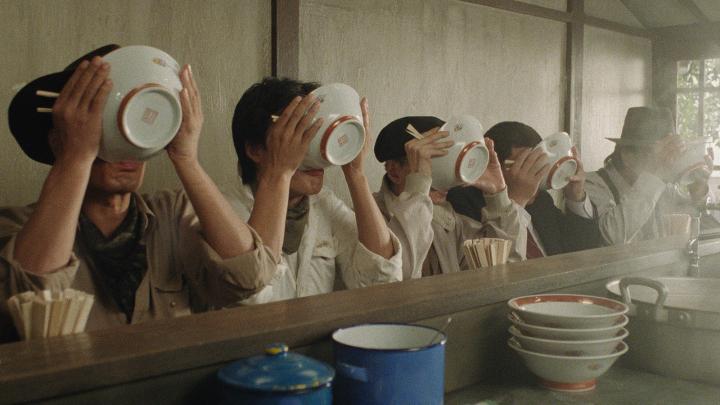 Rangée de personnes avalant leur bol de ramen