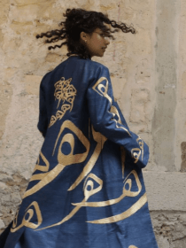 Jeune femme afghane portant un manteau long de la marque Zarif Design