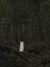 Photographie d'une figure féminine vêtue de blanc dans une forêt intitulée  Hakanai Sonzai #1 par Pierre-Elie de Pibrac