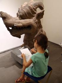 Image de trois enfants dessinant les œuvres du musée